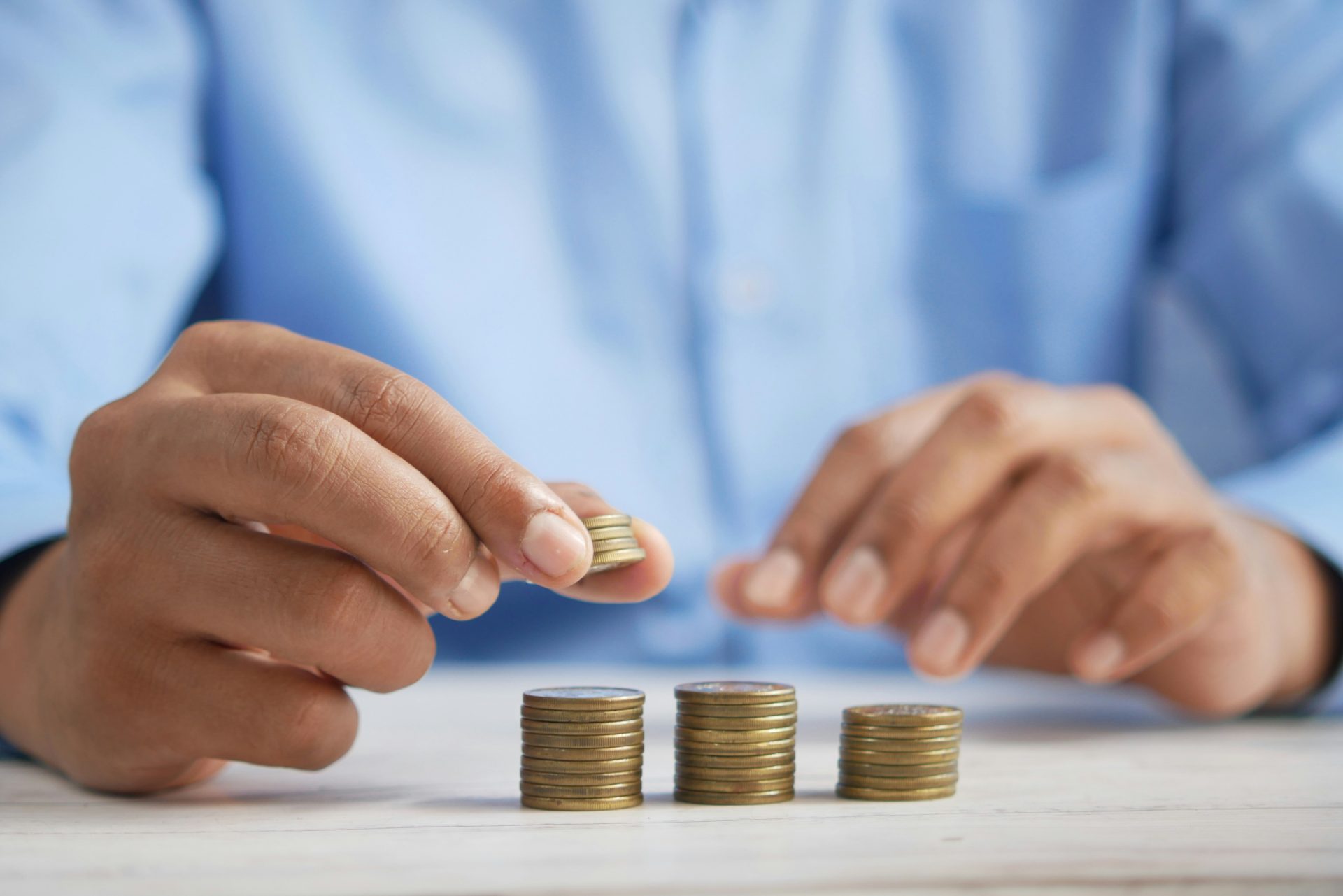 Person stacking coins in neat rows.